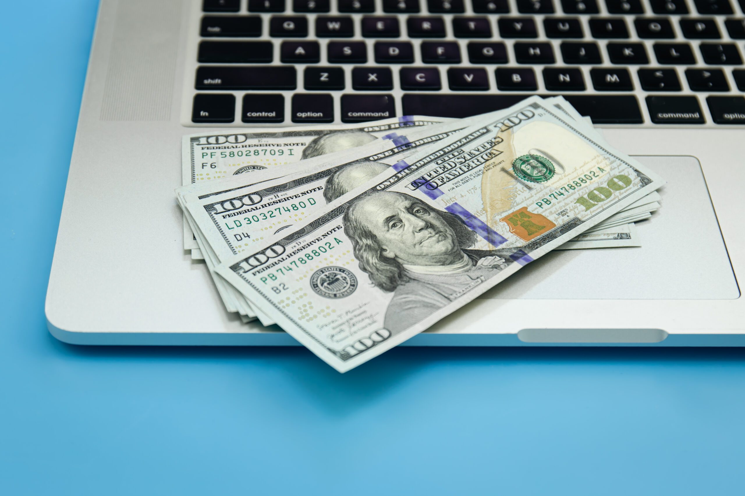 laptop shown with dollar bills Blogging and Making Money From Your Blog