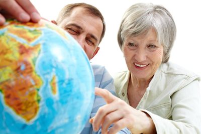 Americans retiring abroad cheerful couple pointing at globe
