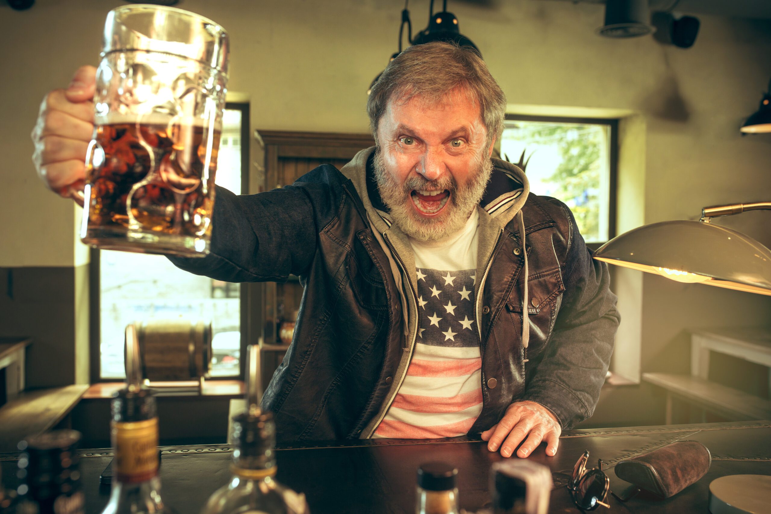 senior drinking home made beer at pub and is wishing he started on home beer brewing